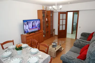 a living room with a table and a television at Céntrico exterior amplio 110 m. in Santiago de Compostela