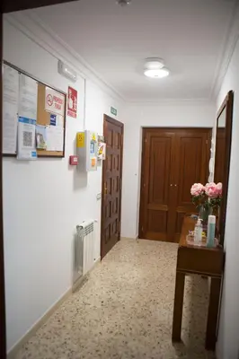 a hallway with a door and a table with flowers on it at Céntrico exterior amplio 110 m. in Santiago de Compostela