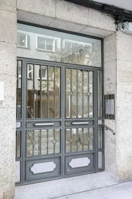 a metal door on a building with a window at Céntrico exterior amplio 110 m. in Santiago de Compostela