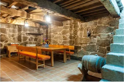 a stone walled room with a wooden table and chairs at Spacious House with Pool in Carballedo in Carballedo