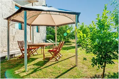 a table and chairs under an umbrella in a yard at Spacious House with Pool in Carballedo in Carballedo