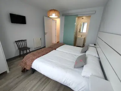 a bedroom with a large white bed and a chair at Casa Luis in Arzúa