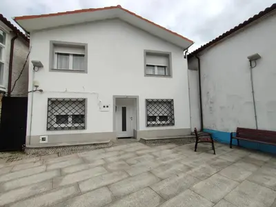 a white house with a bench in front of it at Casa Luis in Arzúa