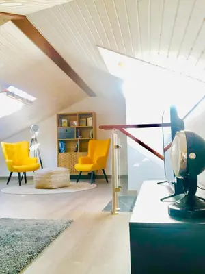 a living room with yellow chairs and a table at Apartamentos Turísticos Casa Dina in Rinlo