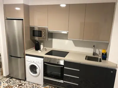 a kitchen with a refrigerator and a washing machine at Apartamentos Turísticos Casa Dina in Rinlo