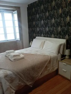 a bedroom with a bed with towels on it at Apartamento en el casco histórico in Santiago de Compostela