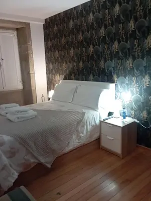 a bedroom with a large bed and a wall with at Apartamento en el casco histórico in Santiago de Compostela