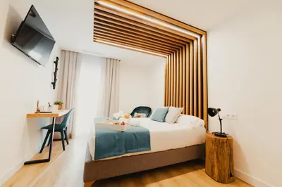 a bedroom with a bed and a table and a desk at HOTEL LOTUS in Caldas de Reis