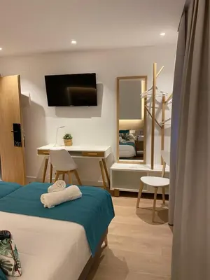 a bedroom with a bed and a desk and a mirror at HOTEL LOTUS in Caldas de Reis