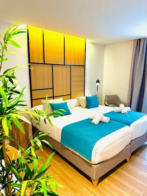 a bedroom with a large bed with blue pillows at HOTEL LOTUS in Caldas de Reis