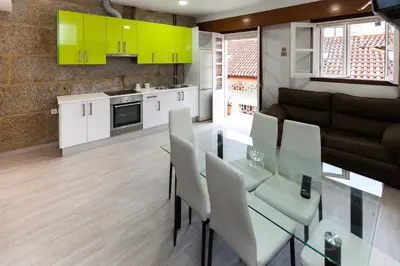a kitchen and living room with a glass table and chairs at Duplex Familiar in Ribadavia