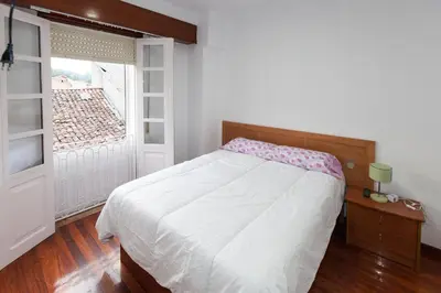 a bedroom with a white bed and a window at Duplex Familiar in Ribadavia