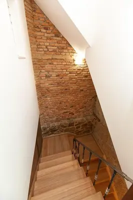 a staircase with a brick wall and a stair case at Duplex Familiar in Ribadavia