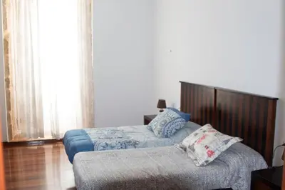 a bedroom with two beds and a couch at Piso Top en Plaza Mayor in Ribadavia