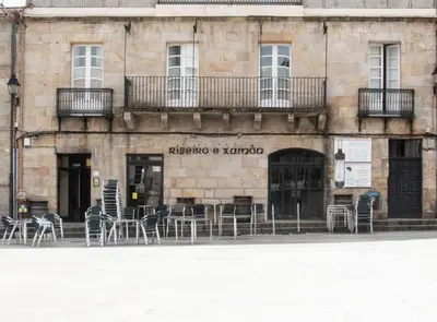 a building with tables and chairs in front of it at Piso Top en Plaza Mayor in Ribadavia