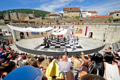 a crowd of people watching a performance on a chessboard at Piso Top en Plaza Mayor in Ribadavia