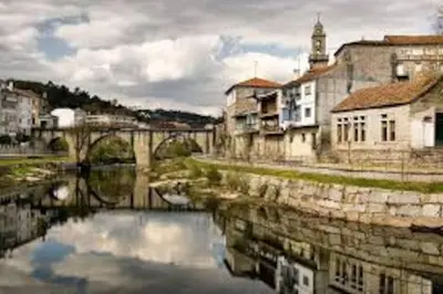 a river in a city with buildings and a bridge at Piso Top en Plaza Mayor in Ribadavia