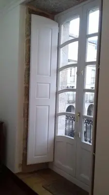 a room with a door and two windows at Piso Top en Plaza Mayor in Ribadavia