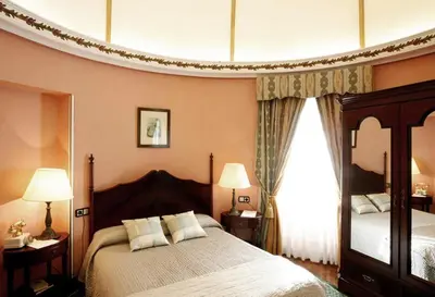 a bedroom with a large bed and a large window at Hotel Palacete Peñalba in Castropol