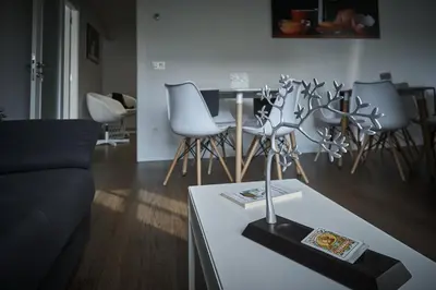 a living room with a couch and a table with chairs at Xabarin Rooms in Abadín