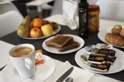 a table with plates of food and a cup of coffee at Xabarin Rooms in Abadín