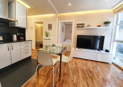 a kitchen with a glass table with chairs and a television at Burgas Termal in Ourense