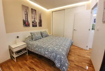 a small bedroom with a bed and a night stand at Burgas Termal in Ourense