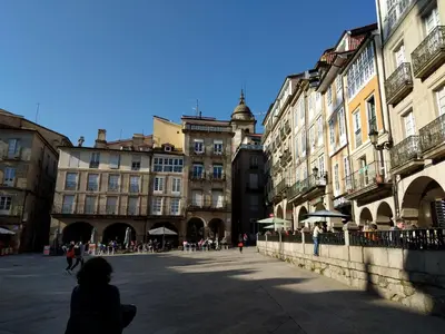a woman walking down a street in a city at Burgas Termal in Ourense