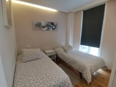 two beds in a small room with a tv at Burgas Termal in Ourense