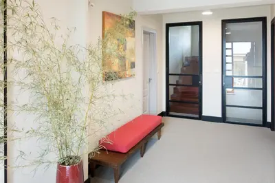 a living room with a red bench and plants at APARTAMENTOS BARCELLA TAPIA in Tapia de Casariego