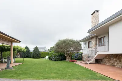 a backyard of a house with a lawn at APARTAMENTOS BARCELLA TAPIA in Tapia de Casariego