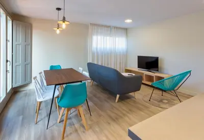 a living room with a table and chairs and a television at APARTAMENTOS BARCELLA TAPIA in Tapia de Casariego