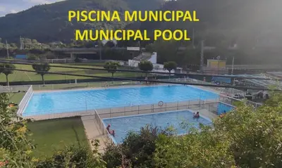 a large swimming pool with the words pisina municipal municipal pool at Hostal Cruce in Villafranca del Bierzo