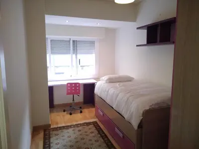 a bedroom with a bed and a desk and a window at YEDRA in Ourense