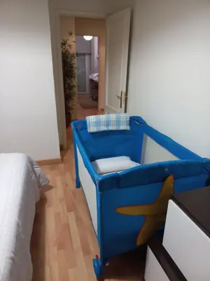 a blue chair in a bedroom with a bed at YEDRA in Ourense