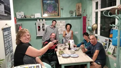 a group of people sitting around a table drinking wine at Oli Vita Hostel ALBERGUE CON ENCANTO in Viveiro