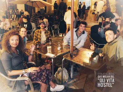 a group of people sitting at tables in a restaurant at Oli Vita Hostel ALBERGUE CON ENCANTO in Viveiro