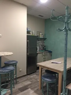 a kitchen with a table and chairs and a refrigerator at Oli Vita Hostel ALBERGUE CON ENCANTO in Viveiro