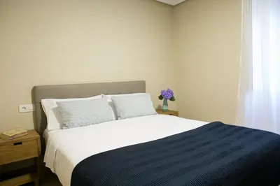 a bedroom with a large bed with a blue and white blanket at Casa Borlas in Vilamelle