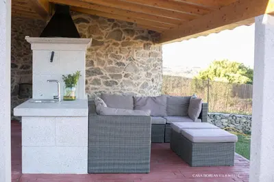 a patio with a couch and a table and a counter at Casa Borlas in Vilamelle