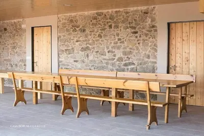 a wooden bench sitting in front of a stone wall at Casa Borlas in Vilamelle