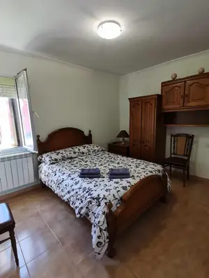 a bedroom with a large bed with blue pillows on it at Casa Carreira Bierzo in Ponferrada