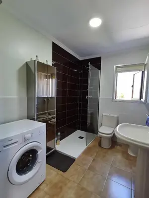 a bathroom with a washing machine and a sink at Casa Carreira Bierzo in Ponferrada
