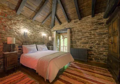 a bedroom with a bed and a brick wall at Casa Bouza in Becerreá