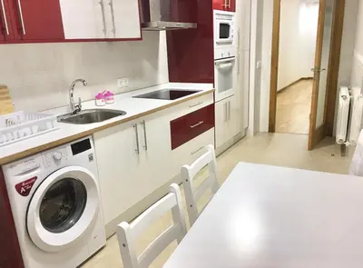 a kitchen with a washing machine and a sink at Piso céntrico próximo a la playa in Burela de Cabo