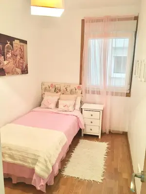 a small bedroom with a bed and a window at Piso céntrico próximo a la playa in Burela de Cabo