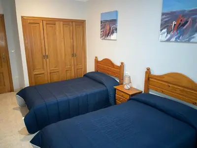 two beds in a bedroom with blue sheets at HOSTAL CID in Ourense
