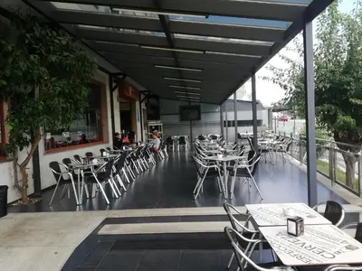 an empty patio with tables and chairs in a restaurant at HOSTAL CID in Ourense