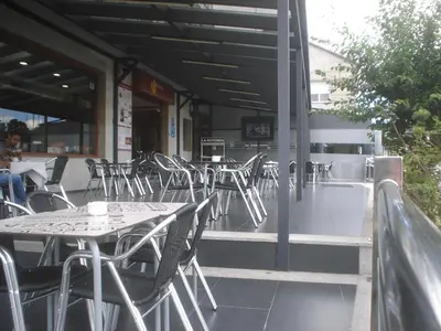 a row of tables and chairs on a patio at HOSTAL CID in Ourense