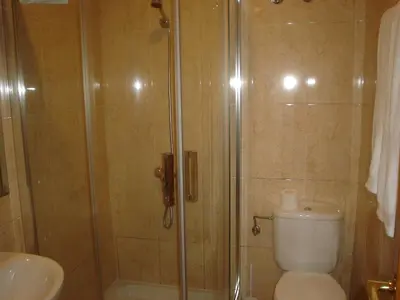 a bathroom with a shower and a toilet and a sink at HOSTAL CID in Ourense